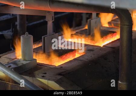 Glashütte. Glasindustrie. Brennen von Rohlingen von Glasflaschen in einem Industrieofen. Heiße Flaschenrohlinge in Flamme. Typische böhmische Arbeit. Tschechische Republik, Stockfoto