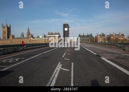 Eine fast trostlose Westminster Bridge, abgesehen von der eigenartigen einsamen Familie oder dem Radfahrer über der Westminster Bridge während der Coronavirus COVID-19 Sperrung Stockfoto