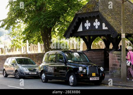 Black Taxi Tour parkte vor der St Peters Church in Woolton Village Liverpool, wo John Lennon und Paul McCartney zum ersten Mal zusammen spielten Stockfoto