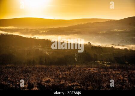 Sonnenaufgang über einem nebelgefüllten Tal Stockfoto