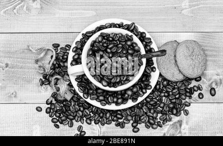 Koffein Konzept. Café Getränke Menü. Arabica robusta Sorte. Trinken für Inspiration und Energie aufladen. Tasse voll Kaffee braun gerösteten Bohne blau Holz- Hintergrund. Frisch geröstete Kaffeebohnen. Stockfoto