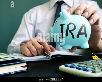 IRA individuelles Pensionierungskonto Konzept. Der Manager schlägt ein Sparschwein vor. Stockfoto