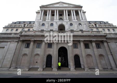 Der Wachmann steht vor der Bank of England in der City of London, die Straßen waren leer wegen der Sperrung des Coronavirus Covid 19. Stockfoto