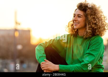 Porträt einer jungen Frau mit lockigen Haaren in der Stadt Stockfoto