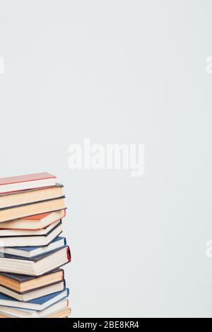 Viele Stapel von Lehrbüchern, die in der Bibliothek auf weißem Hintergrund gelehrt werden Stockfoto