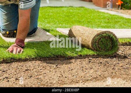 Gartenarbeit - Gärtner legt Spatenstich für den neuen Rasen Stockfoto