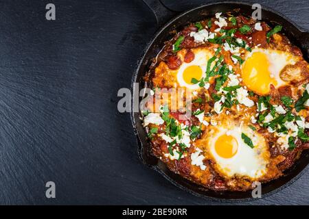Shakshouka - Nahost traditionelle Gericht mit pochierten Eiern in Tomatensauce mit Feta-Käse Stockfoto