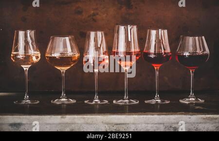 Nuancen von Roséwein in Gläsern mit rostigem Hintergrund Stockfoto