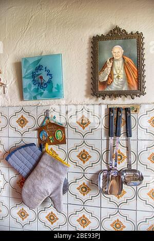 Verona, Italien - 10. September 2015: Detail einer alten Küche mit Topflappen, Schöpfkellen und einem gerahmten Bild von San Giovanni XXIII (Angelo Giuseppe Roncall.1 Stockfoto