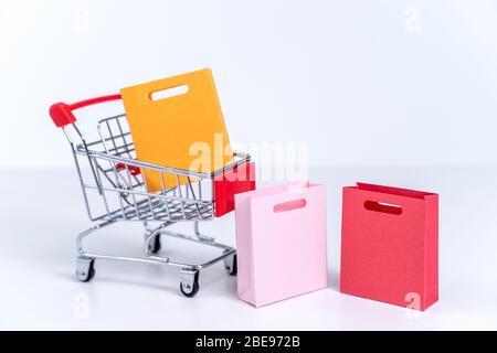 Einkaufstaschen in einem silberroten Warenkorb isoliert auf weißem Tisch Hintergrund, Konzept des Aufenthalts nach Hause Ordnung, Nahaufnahme, kopieren Raum Design. Stockfoto