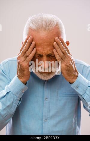 Porträt eines älteren Mannes, der Kopfschmerzen hat. Stockfoto