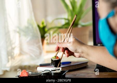 Bestellen und AET Sushi zu Hause während der Quarantäne. Sushi aus einer Kiste nach Hause holen. Stockfoto