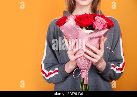 Close-up schönen Blumenstrauß mit Rosen auf Frauen Hände auf gelbem Hintergrund. Floristen erstellen schöne Blumenstrauß Stockfoto