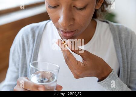 Frau hält Pillen und Glas Wasser in den Händen Stockfoto