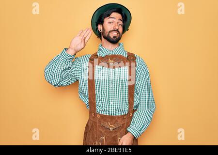 Junger schöner Mann trägt tratidional deutschen oktoberfest Custome für Deutschland Festival verzichten sagen hallo glücklich und lächelnd, freundlich willkommen gestur Stockfoto