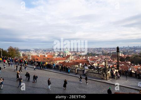 PRAG, TSCHECHISCHE REPUBLIK - 2. NOVEMBER 2019: Touristen vor der Prager Burg mit Skyline am 2. November 2019 in Prag, Tschechische Republik. Stockfoto