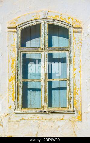 Altes Fenster mit weißer und gelber Farbe, die sich abblättert Stockfoto