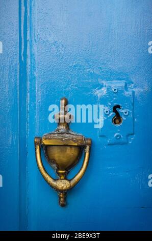 Alter Türknopf aus Messing und Schlüsselloch in einer blauen Tür Stockfoto