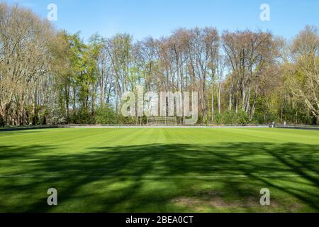 Leeres Fußballtrainingsstatum, grün im Sonnenlicht, kein Training oder spielende Menschen Stockfoto