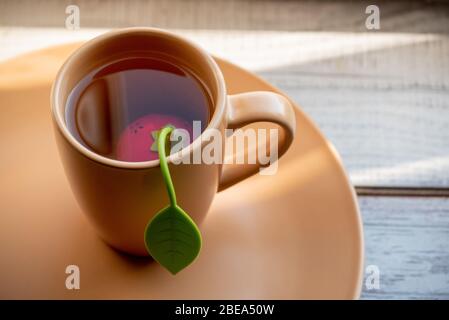 Tasse Tee zum Frühstück. Kopierbereich. Beiger Hintergrund. Stillleben mit Teetaßetaßetaßaufnahme. Tea Time Konzept. Leckeres Getränk. Tee in einer beigen Tasse. Stockfoto