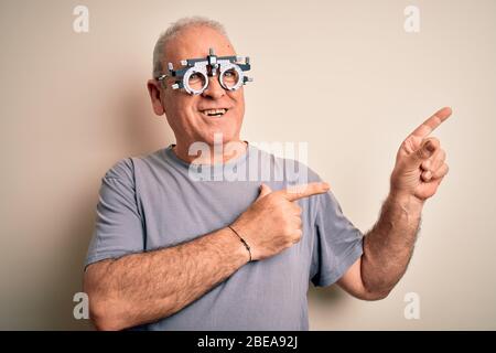 Mittelalter Hoary Mann Kontrolle Vision trägt Optometrie Brille über weißem Hintergrund lächelnd und Blick auf die Kamera mit zwei Händen und zeigen Stockfoto