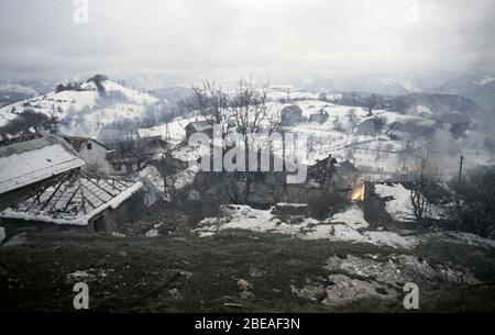 26. Januar 1994 während des Krieges in Zentralbosnien: Gebäude schwelen und brennen zwei Tage, nachdem Soldaten der Rama-Brigade der HVO das bosnisch-muslimische Dorf hier eingenommen haben. Stockfoto