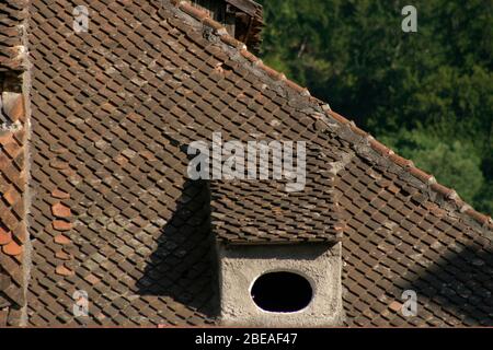 Dachfenster auf Haus mit original Tonfliesen in der Altstadt von Brasov, Rumänien bedeckt Stockfoto