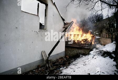 26. Januar 1994 während des Krieges in Zentralbosnien: Gebäude schwelen und brennen zwei Tage, nachdem Soldaten der Rama-Brigade der HVO das bosnisch-muslimische Dorf hier eingenommen haben. Stockfoto