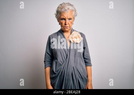Senior schöne grauhaarige Frau in lässigem Kleid über weißem Hintergrund stehen skeptisch und nervös, Stirnrunzeln aufgeregt wegen des Problems. Negativ Stockfoto