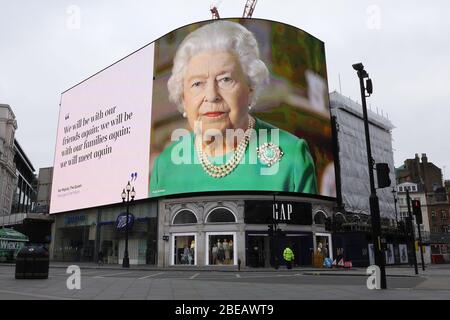 London, Großbritannien. April 2020. Auf einer Leinwand ist die britische Königin Elizabeth II. Zu sehen und ein Zitat aus ihrer Rede zum Kampf gegen COVID-19 am Piccadilly Circus in London, Großbritannien, 13. April 2020. Die Todesrate derjenigen, die in Großbritannien hospitalisiert wurden und positiv auf das neuartige Coronavirus getestet wurden, erreichte am Samstagnachmittag 10,612, sagte das Ministerium für Gesundheit und Soziales am Sonntag. Kredit: Tim Ireland/Xinhua/Alamy Live News Stockfoto