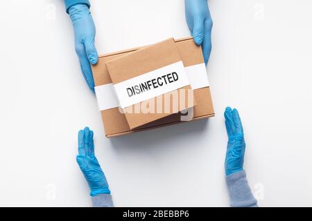 Hände in Handschuhen auf Quarantäne erhalten Lieferbox Stockfoto