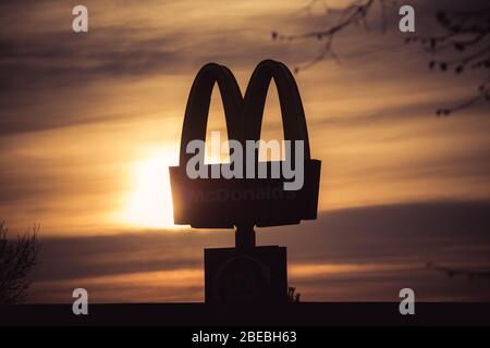 Die berühmten goldenen Bögen von McDonalds ragten gegen den Himmel des Sonnenaufgangs Stockfoto