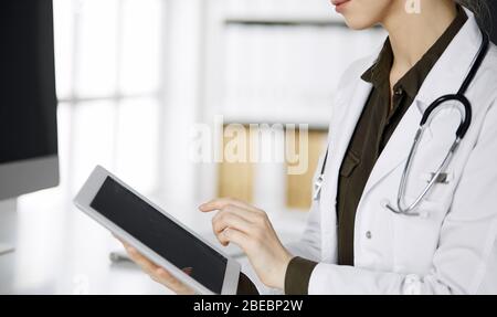 Unbekannter weiblicher Arzt mit Tablet-Computer in der Klinik. Perfekter medizinischer Service im Krankenhaus. Medizinkonzept Stockfoto