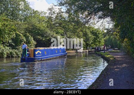 Schmales Boot nähert sich Schleuse auf dem Grand Union Canal in der Nähe von Hanwell West London England Großbritannien Stockfoto