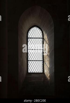 Details von Licht, Fenstern, Mauerwerk und Schatten innerhalb einer klassischen europäischen Kirche. Stockfoto