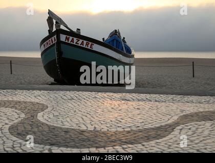 Ein traditionelles Fischerboot mit portugiesischem Pflaster in Nazare gesehen einer der beliebtesten Badeorte an der Silberküste (Costa da Prata) Portugal. Stockfoto