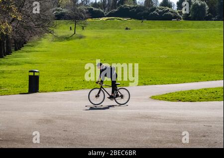 Glasgow, Schottland, Großbritannien. April 2020. Am Ostermontag während der Sperrung der Coronavirus-Pandemie nimmt ein Radfahrer an einem warmen sonnigen Nachmittag im Queen's Park Sport. Kredit: Skully/Alamy Live News Stockfoto