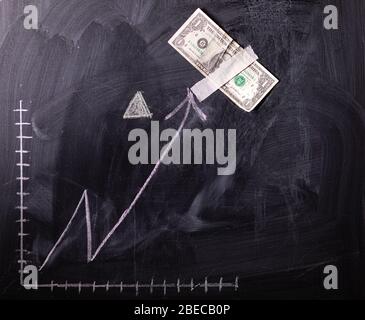 Auf dem Schwarzen Brett gezeichnete Wachstumskarte des Dollars. Investitionskonzepte und Interessen Unternehmenswachstum. Steigende Grafik aus Dollars. Stockfoto