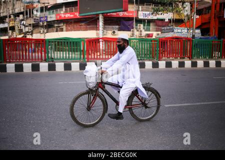 Dhaka, Bangladesch. April 2020. (4/10/2020) EIN Mann geht in einem Zyklus während der Sperrsituation, die durch CoVid-19 verursacht wird, zu seinem Bestimmungsort. (Foto: MD. Rakibul Hasan/Pacific Press/Sipa USA) Quelle: SIPA USA/Alamy Live News Stockfoto