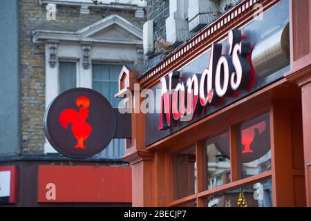 LONDON - DEZEMBER 2019: Nando's Außenschild - eine Kette von beliebten gegrillten Hühnerrestaurants Stockfoto