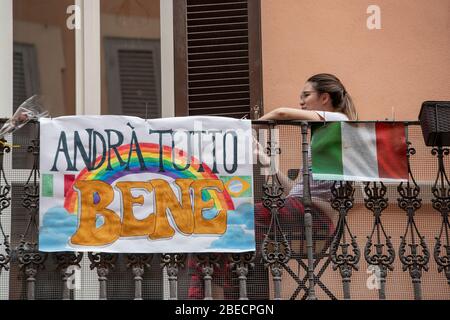 Rom, Italien. April 2020. Ein Mädchen auf einem Balkon in der Via del Corso. Leere Straßen im Stadtzentrum während des Coronavirus (Covid-19) Notfalls in Rom. (Foto: Davide Fracassi/Pacific Press) Quelle: Pacific Press Agency/Alamy Live News Stockfoto