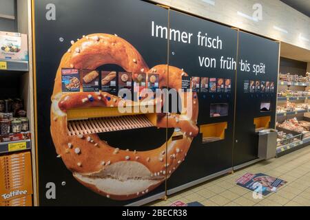Automatische Brot-, Mini-Pizza-, Brezel- und Croissant-Maschine (Backwaren) in einem Aldi Süd Supermarkt in Salzburg, Österreich. Stockfoto
