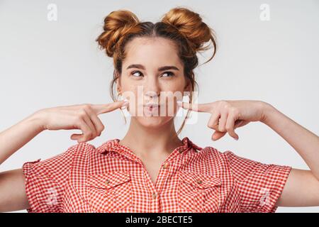 Nahaufnahme eines schönen fröhlichen jungen Teenager-Mädchen tragen Sommerkleidung isoliert über grauem Hintergrund stehen, Spaß zu haben Stockfoto