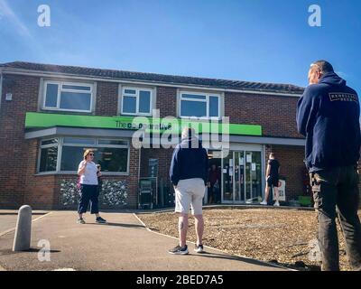 High Wycombe, Großbritannien. April 2020. Am Osterfeiertag am Montag während der Covid-19 Pandemie stehen Sie vor einem lokalen CO-OP-Geschäft Schlange, da die britische Regierung am 13. April 2020 in High Wycombe anraten sollte, die soziale Distanz zu wahren und die Zeit draußen zu minimieren. Kredit: Prime Media Images/Alamy Live News Stockfoto