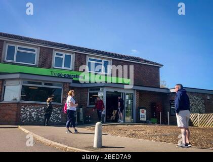 High Wycombe, Großbritannien. April 2020. Am Osterfeiertag am Montag während der Covid-19 Pandemie stehen Sie vor einem lokalen CO-OP-Geschäft Schlange, da die britische Regierung am 13. April 2020 in High Wycombe anraten sollte, die soziale Distanz zu wahren und die Zeit draußen zu minimieren. Kredit: Prime Media Images/Alamy Live News Stockfoto