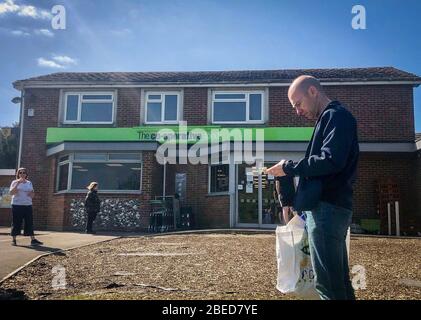 High Wycombe, Großbritannien. April 2020. Am Osterfeiertag am Montag während der Covid-19 Pandemie stehen Sie vor einem lokalen CO-OP-Geschäft Schlange, da die britische Regierung am 13. April 2020 in High Wycombe anraten sollte, die soziale Distanz zu wahren und die Zeit draußen zu minimieren. Kredit: Prime Media Images/Alamy Live News Stockfoto