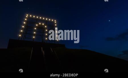 Nachtaufnahme des beleuchteten Denkmals auf der Spitze des Spotter's Hill in Hoofddorp, aufgenommen von der Hälfte der Treppe nach oben. Stockfoto