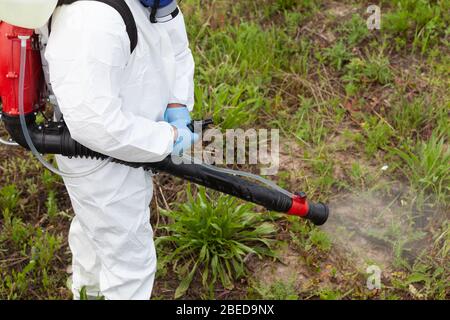 Arbeiter in Schutzanzug Spray Desinfektionsmittel während der Coronavirus-Pandemie. Desinfektions- und Dekontaminationskonzept. Stockfoto