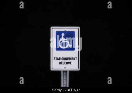 Symbol für Behindertenparkplatz auf schwarzem Hintergrund in französisch geschrieben Stockfoto