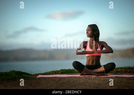 Junge Frau Yoga am Strand. Stockfoto